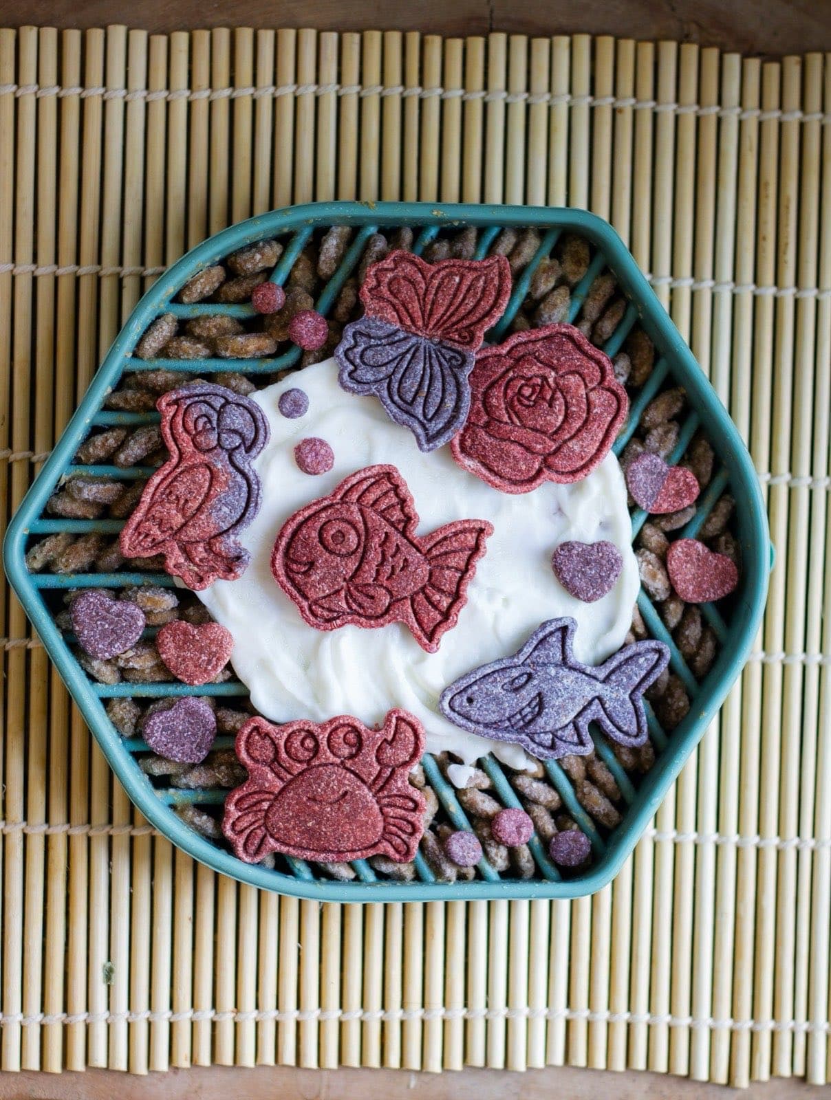 Tapis de léchage hexagonal tartiné de yogourt et garni de biscuits